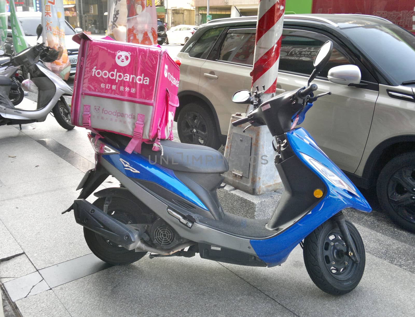 KAOHSIUNG, TAIWAN -- MARCH 8, 2020: A scooter with an insulated container by food delivery service Foodpanda is parked by the side of the road.