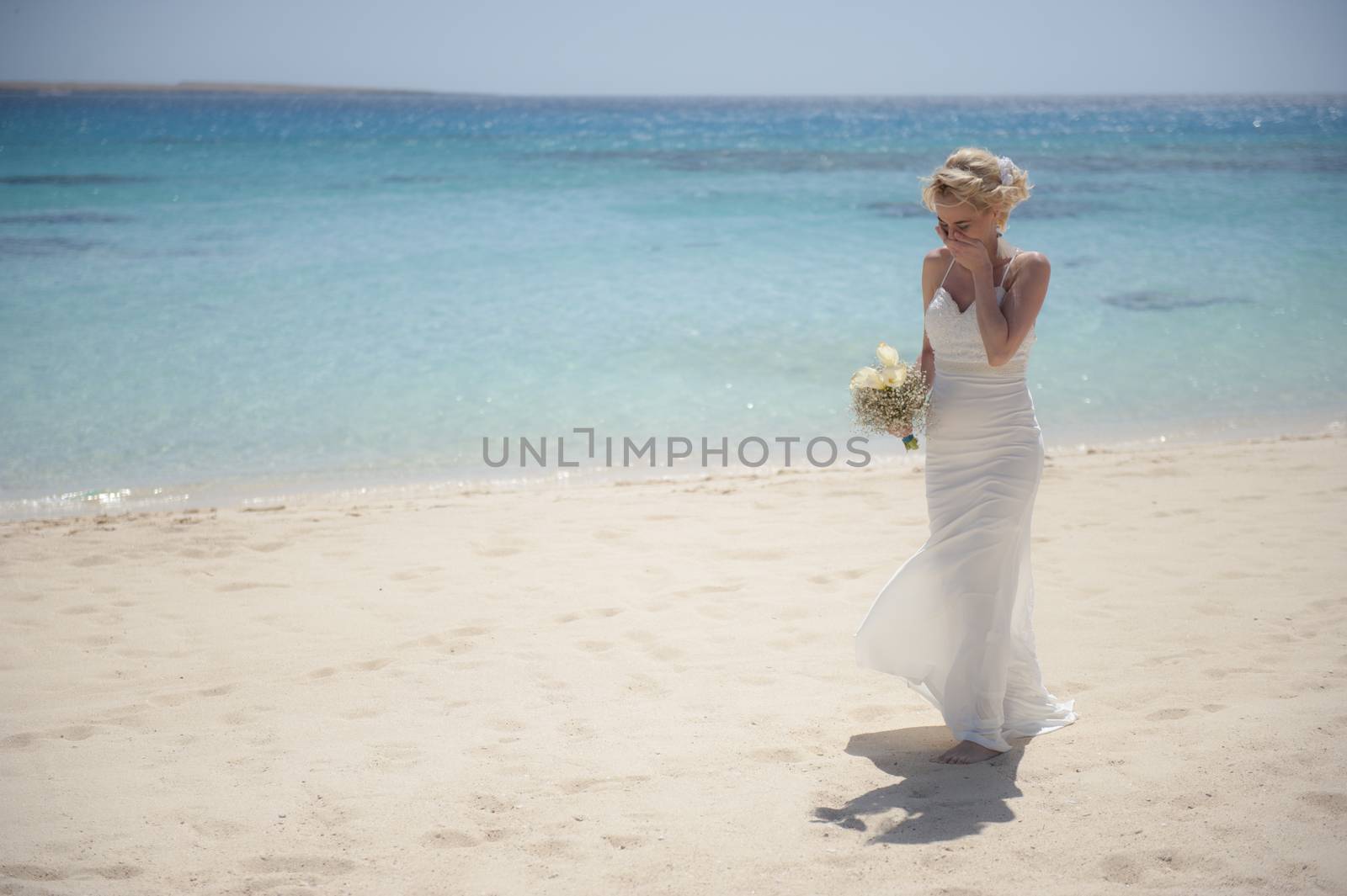 Beautiful woman bride at a tropical beach paradise on wedding day in white gown dress with ocean view