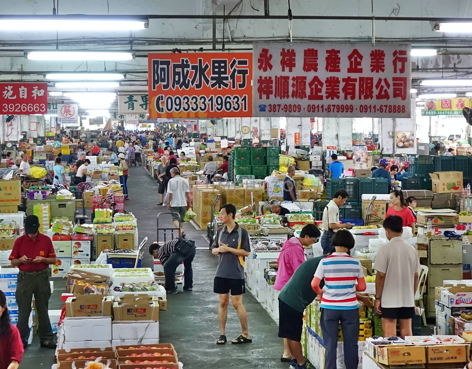 KAOHSIUNG, TAIWAN -- OCTOBER 13, 2018: Wholesale as well as retail shoppers look at fruit at the central fruit and vegetable market in Kaohsiung City.
