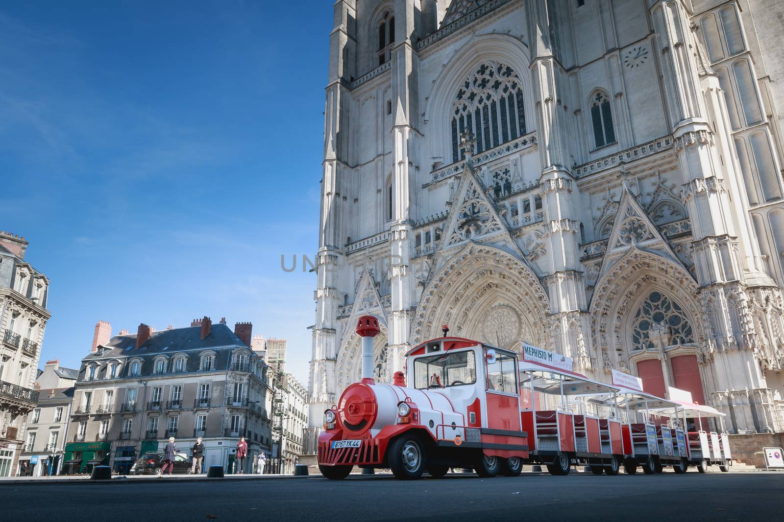 Nantes, France - September 29, 2018: Small tourist train parked in front of the forecourt of Saint Pierre Cathedral in Nantes on a summer day