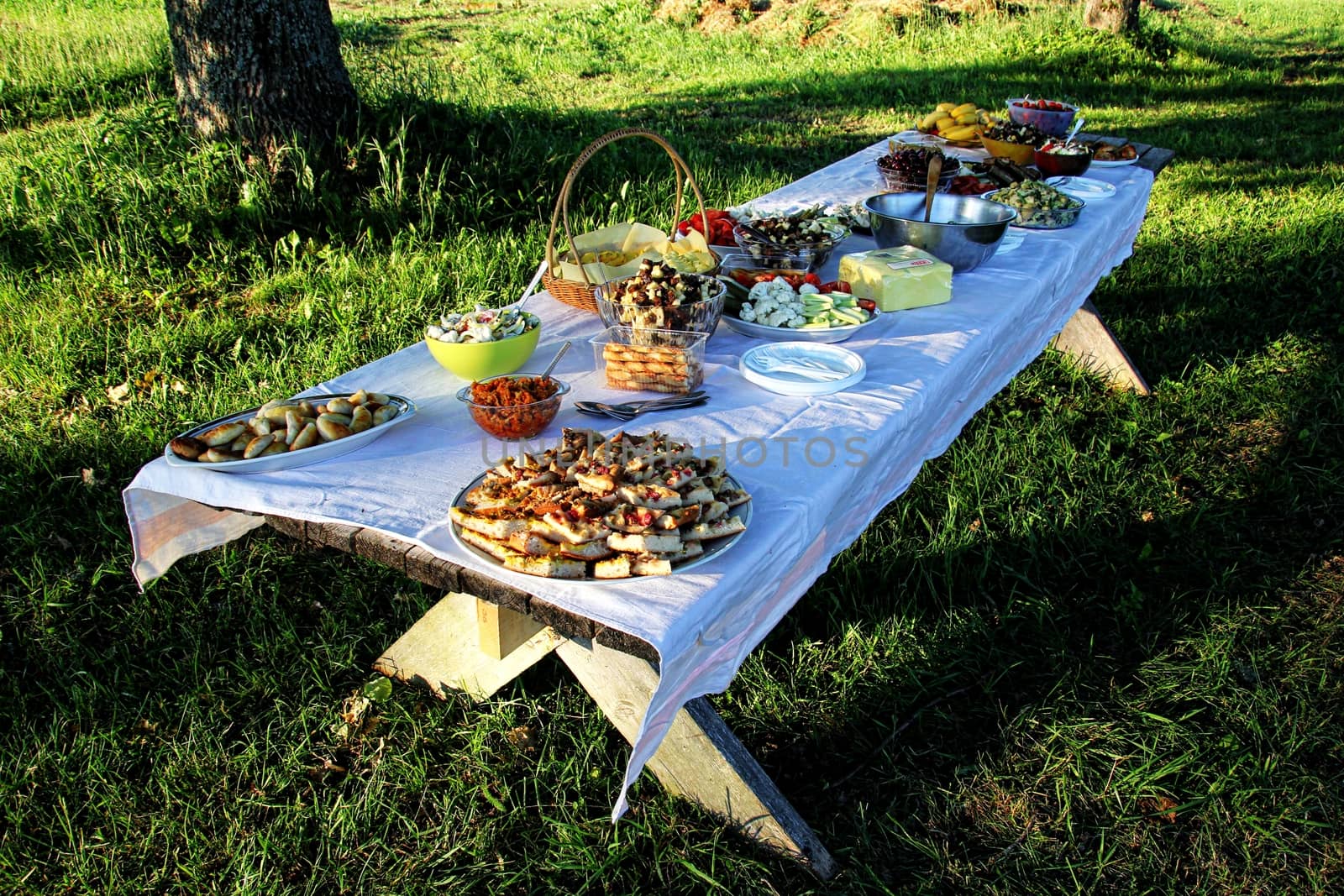 Wooden table under oaks with traditional Latvian food. Old Latvian culture tradition LIGO. Midsummer night celebrating in Latvia.