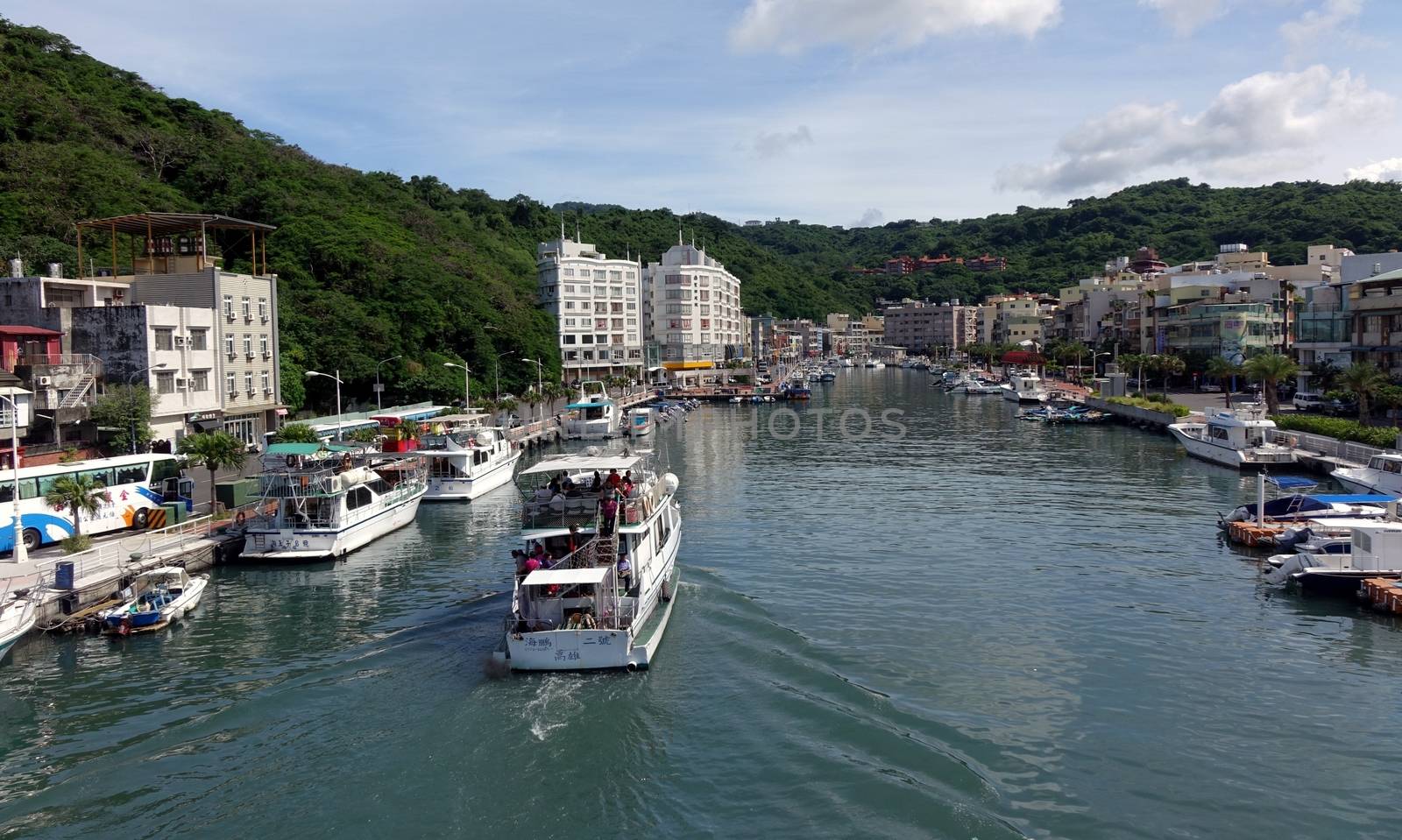 KAOHSIUNG, TAIWAN -- JULY 10, 2014: A pleasure boat returns to the Gushan marina next to the port of Kaohsiung city.