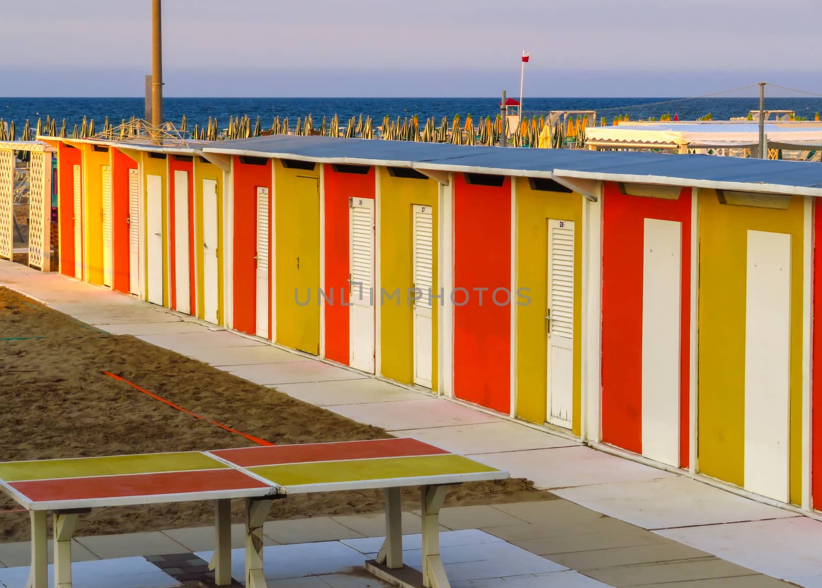 Yellow and red beach cabins in Rimini, Emilia-Romagna, Italy