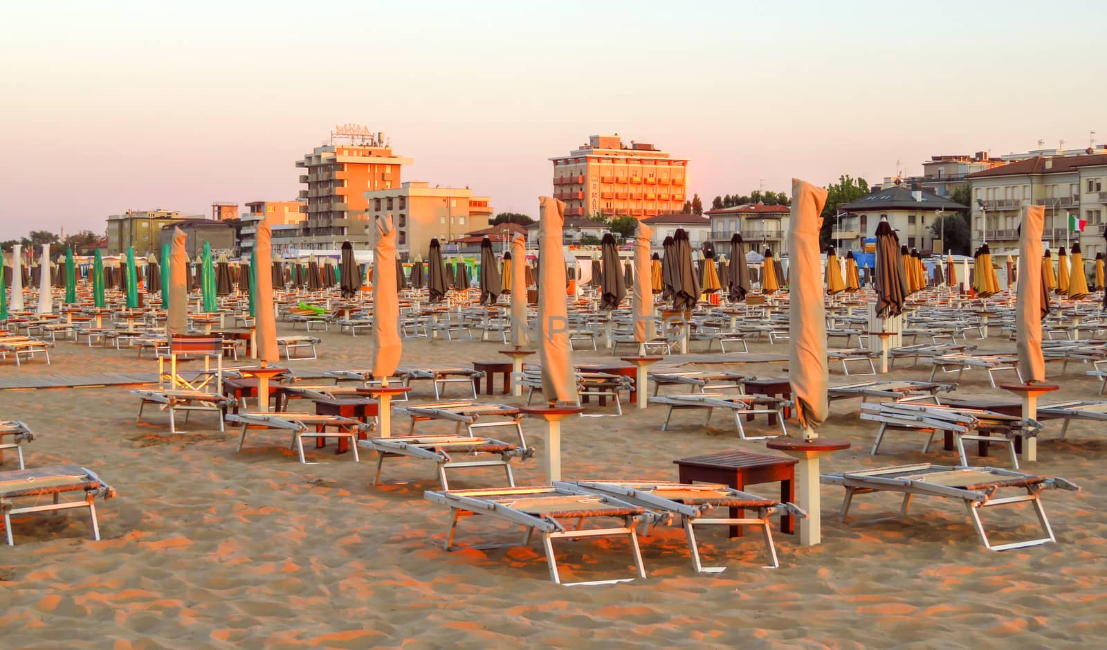 Rimini, Italy - June 14, 2017: Evening Rimini beach with sun beds and umbrellas.