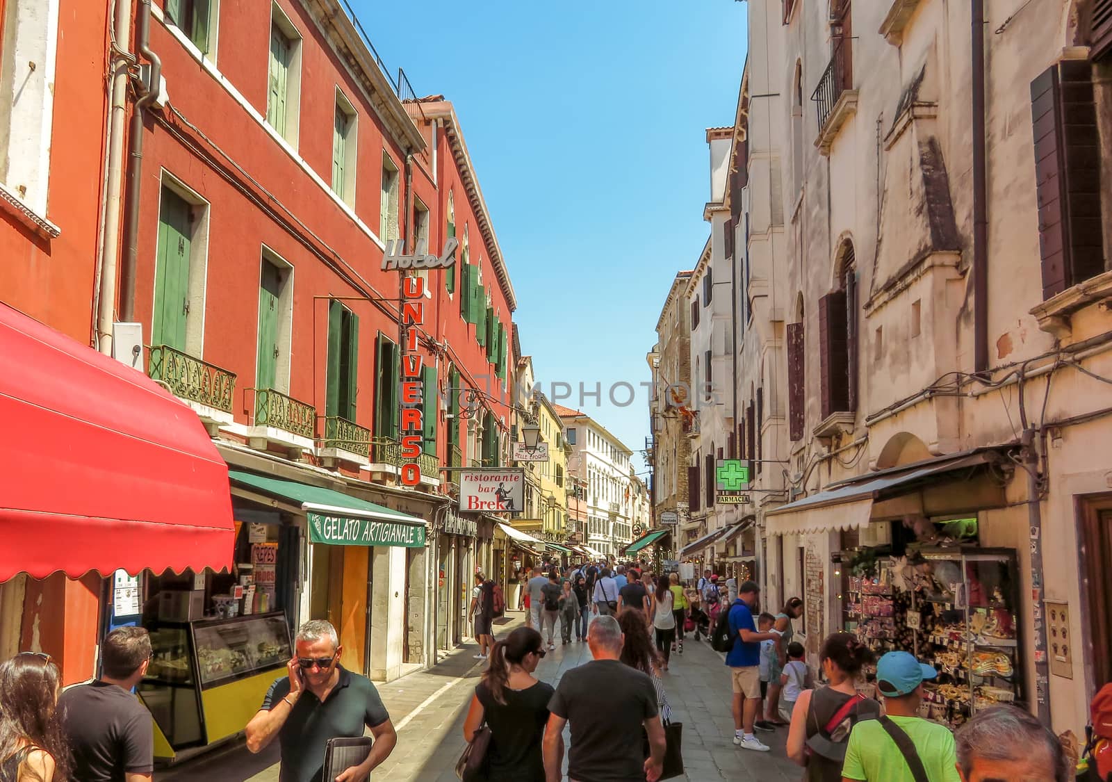 Venice, Italy - June 20, 2017: Architecture of old city in Venice, Italy. Unrecognizable people are walking down the street in the old center.