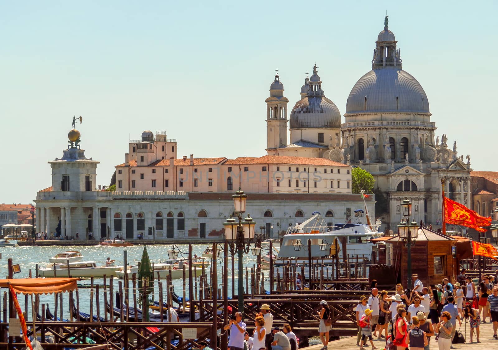 Venice, Italy - June 20, 2017: View to old cathedral of Santa Maria della Salute in Venice, Italy. Unrecognizable people are walking down the street in the old center.