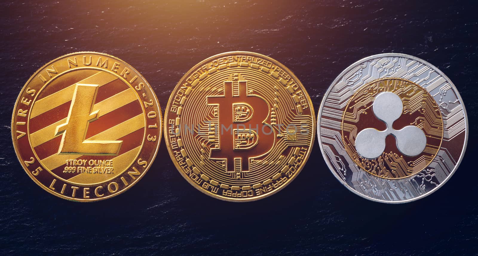Bitcoin, litecoin and ripple coins currency finance money on graph chart background. Bitcoin as most important cryptocurrency concept. Stack of cryptocurrencies with a golden bitcoin in the middle.