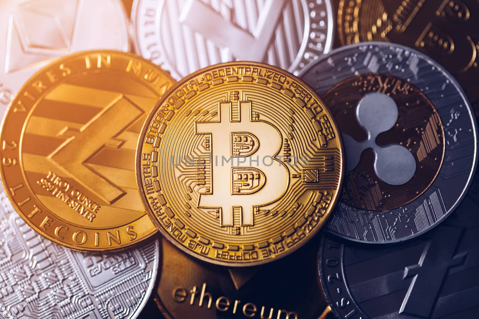 Bitcoin, litecoin and ripple coins currency finance money on graph chart background. Bitcoin as most important cryptocurrency concept. Stack of cryptocurrencies with a golden bitcoin in the middle.