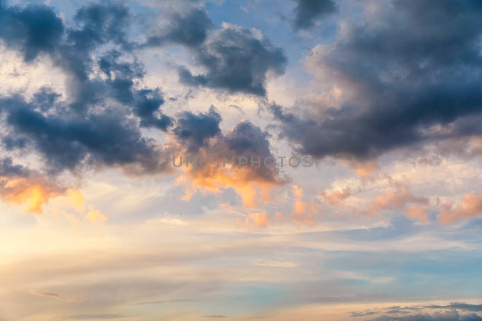 Beautiful sunset sky above clouds with dramatic light. Sunset sky for background, sunrise sky and clouds. Bright orange and blue sky and light of the sun. Beautiful sky with cloud before sunset.