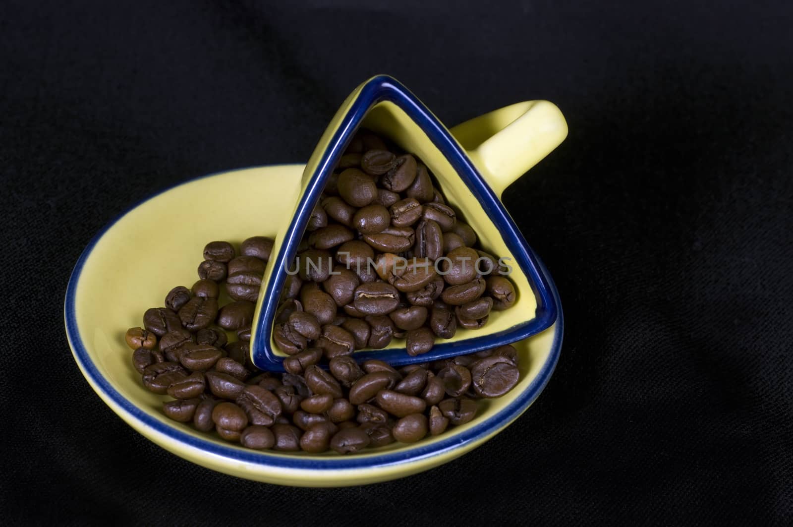 A yellow coffee cup and coffee beans