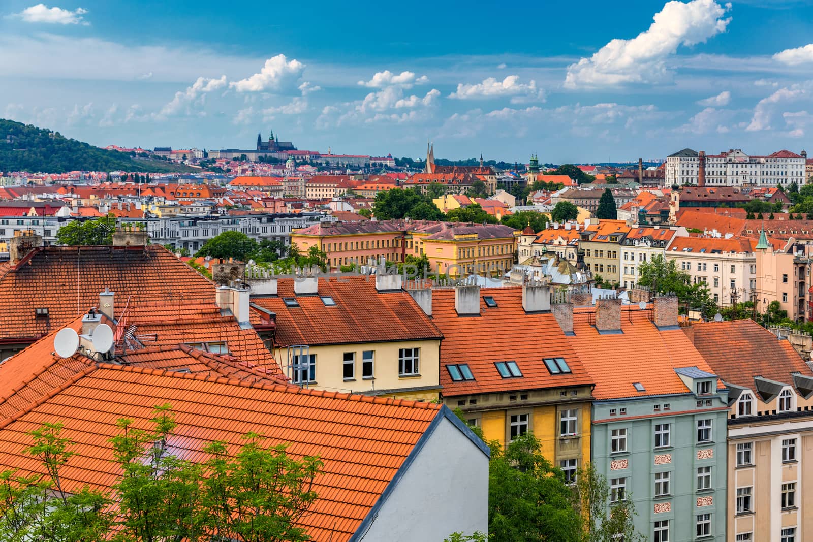 View of Prague Castle over red roof from Vysehrad area at sunset lights, Prague, Czech Republic. Scenic view of Prague city, Prague castle and Petrin tower from Vysehrad overlooking red roofs 