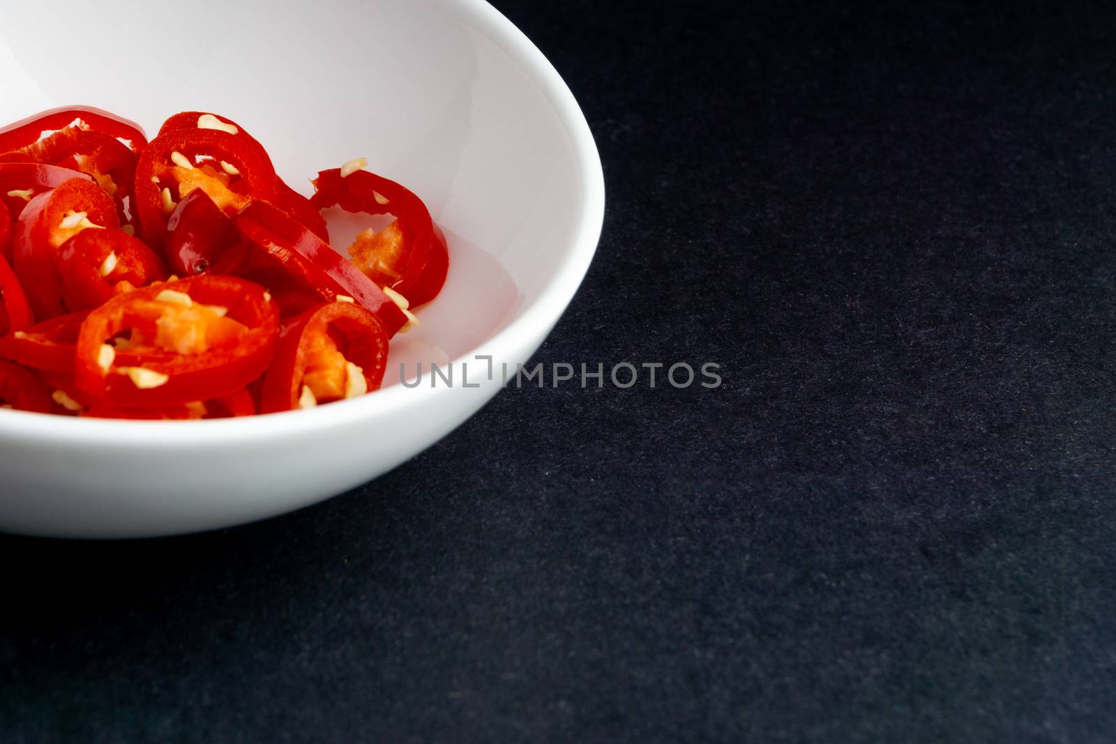 Spicy slice of red chillies closeup on black background