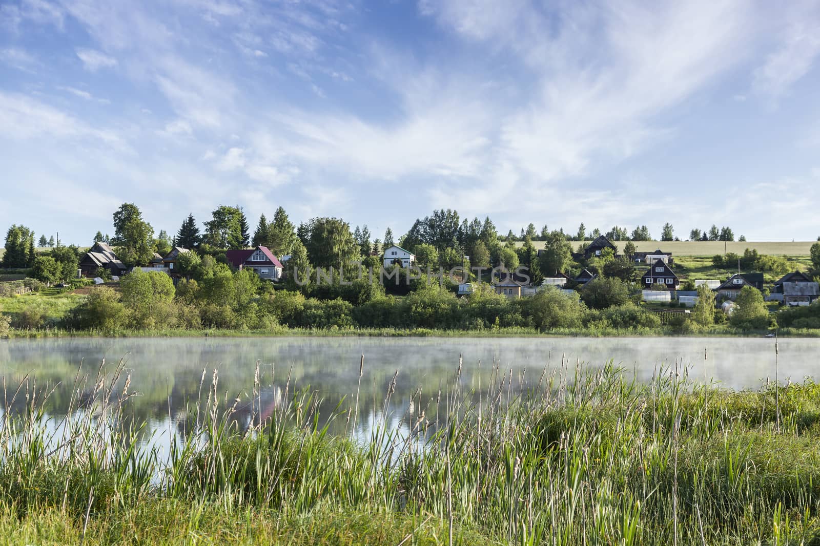 Idyllic landscape. The sky and the forest are reflected in the river.