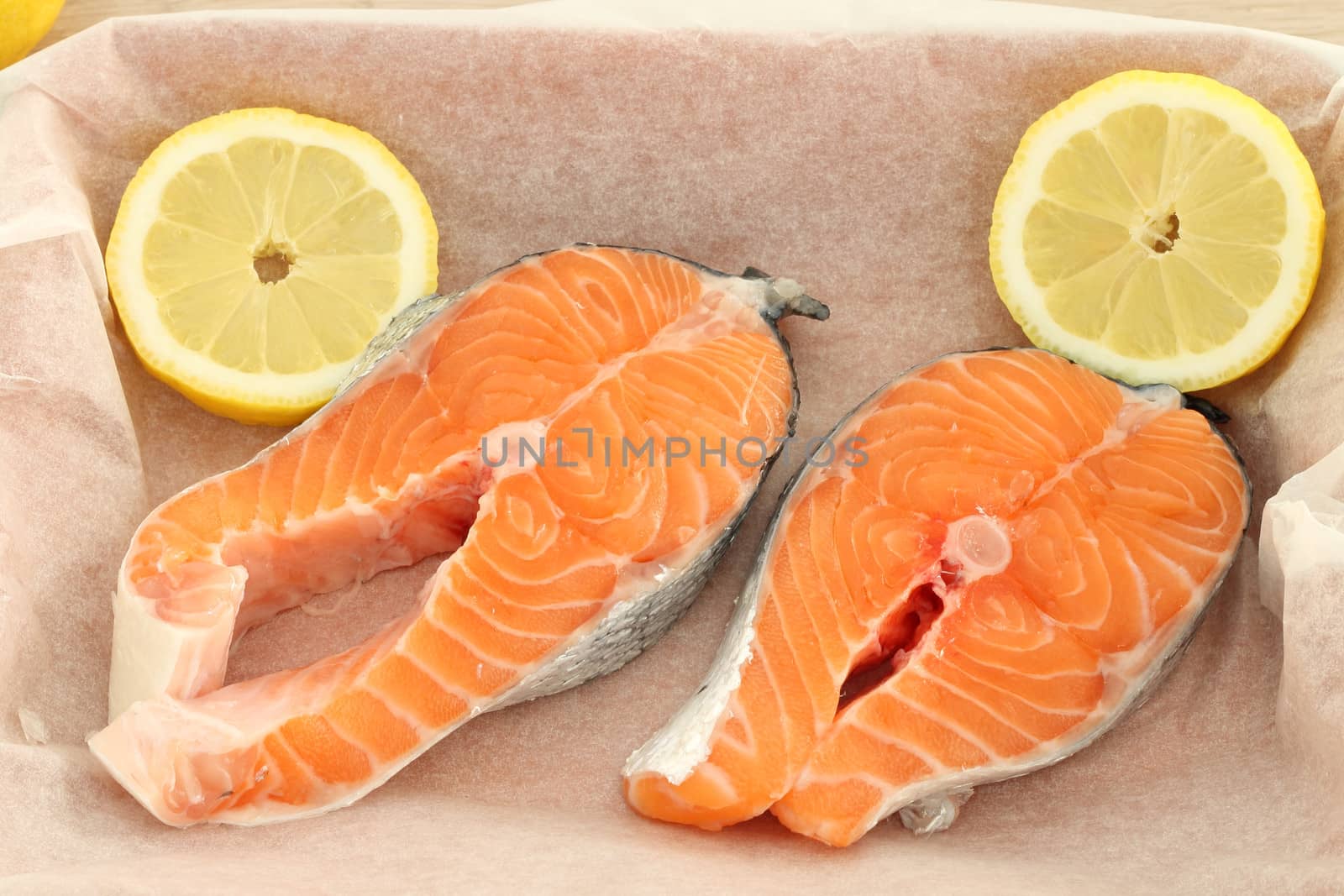 Raw fresh salmon steaks on baking paper