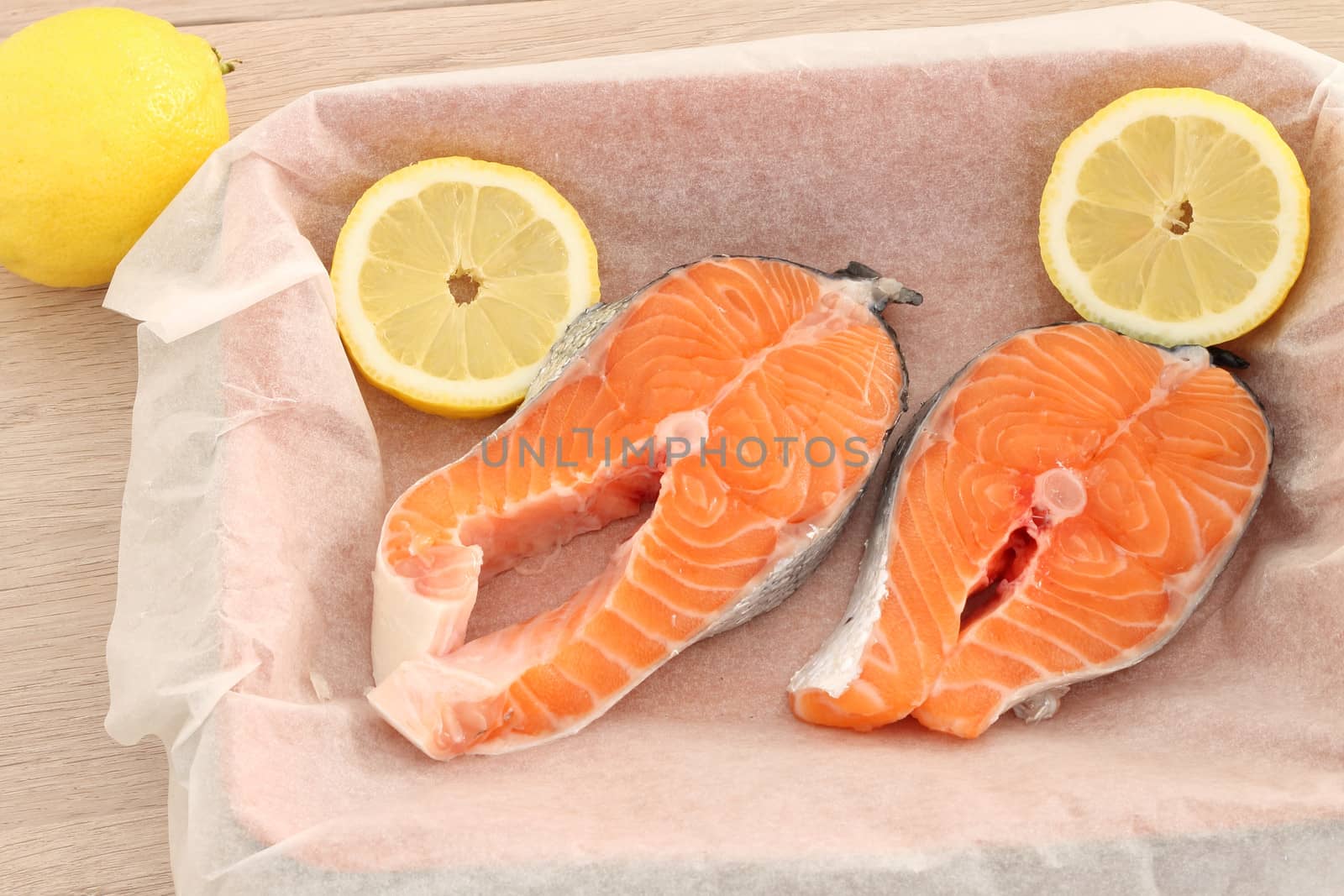 Raw fresh salmon steaks on baking paper