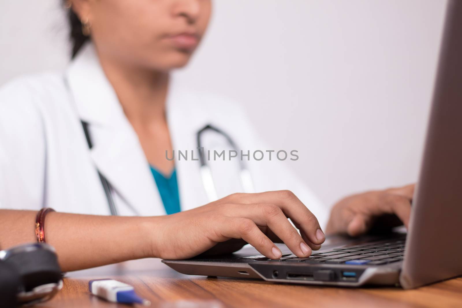 Close-up of doctor hands busy in working on laptop - Online Chat, telehealth, or tele counseling with Patient on computer during coronavirus or covid-19 pandemic. by lakshmiprasad.maski@gmai.com