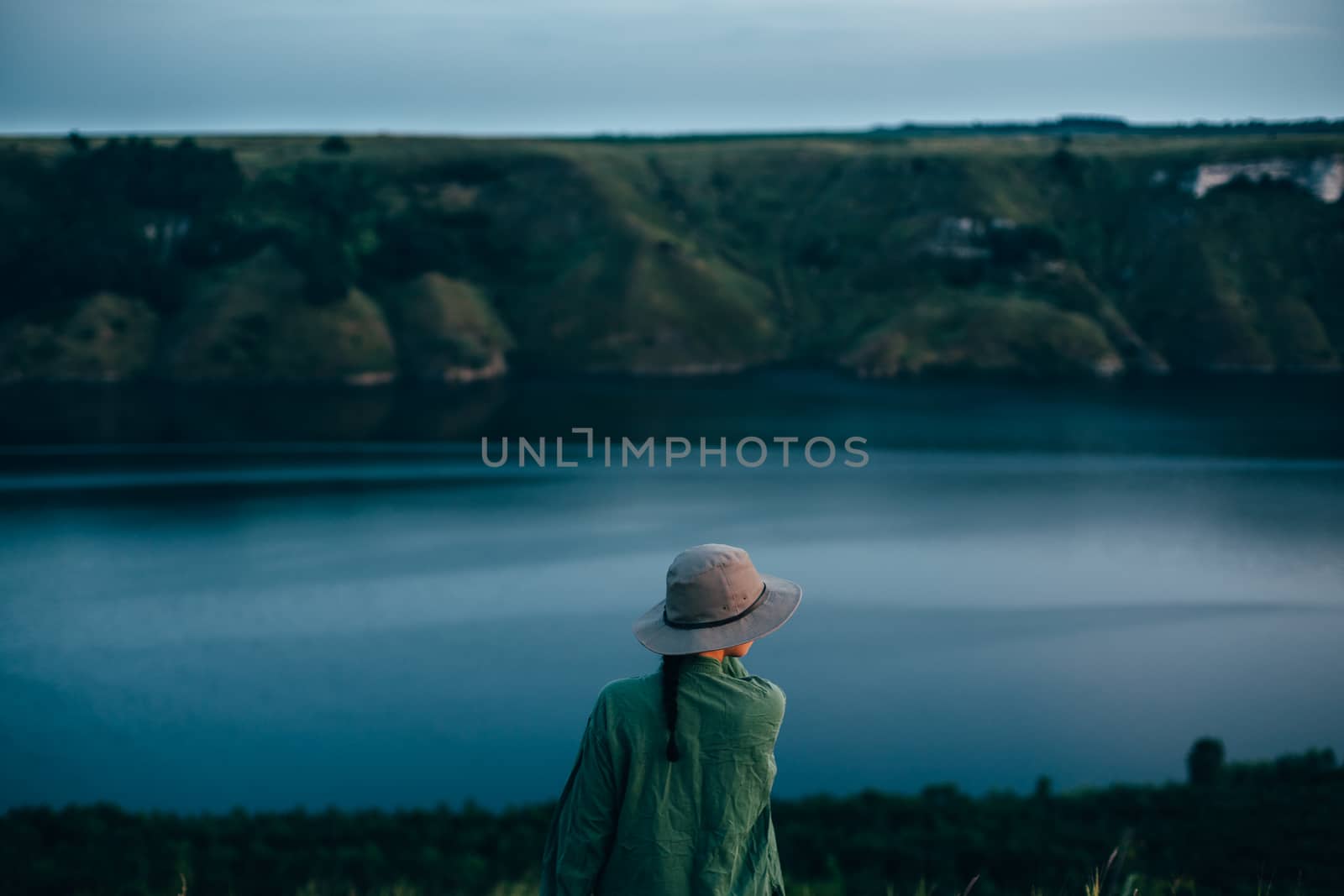 A girl stands on top of a mountain against the backdrop of a lar by Opikanets