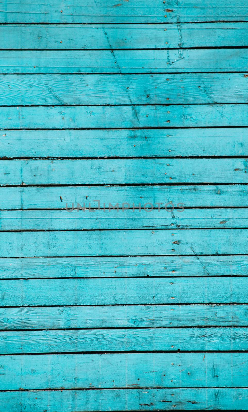Blue wooden boards in the sunlight with a shadow from the tree. Texture of painted wood.