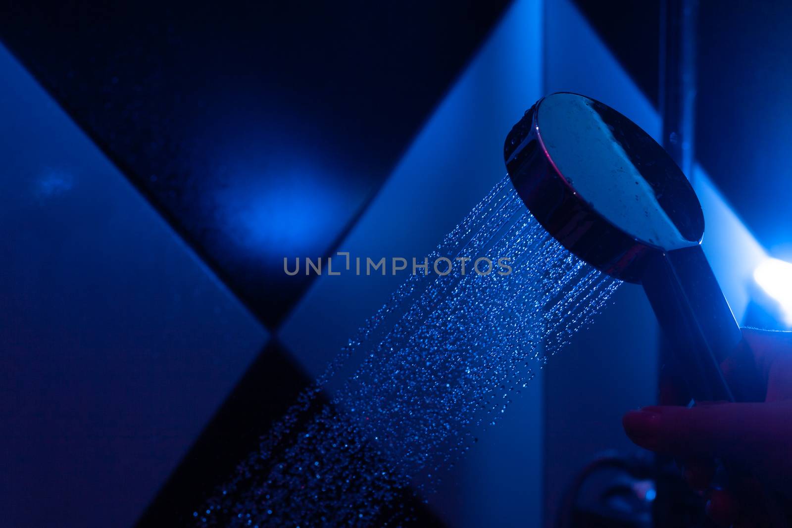 Girl holds a watering can in a shower cabin with blue backlight. by Opikanets