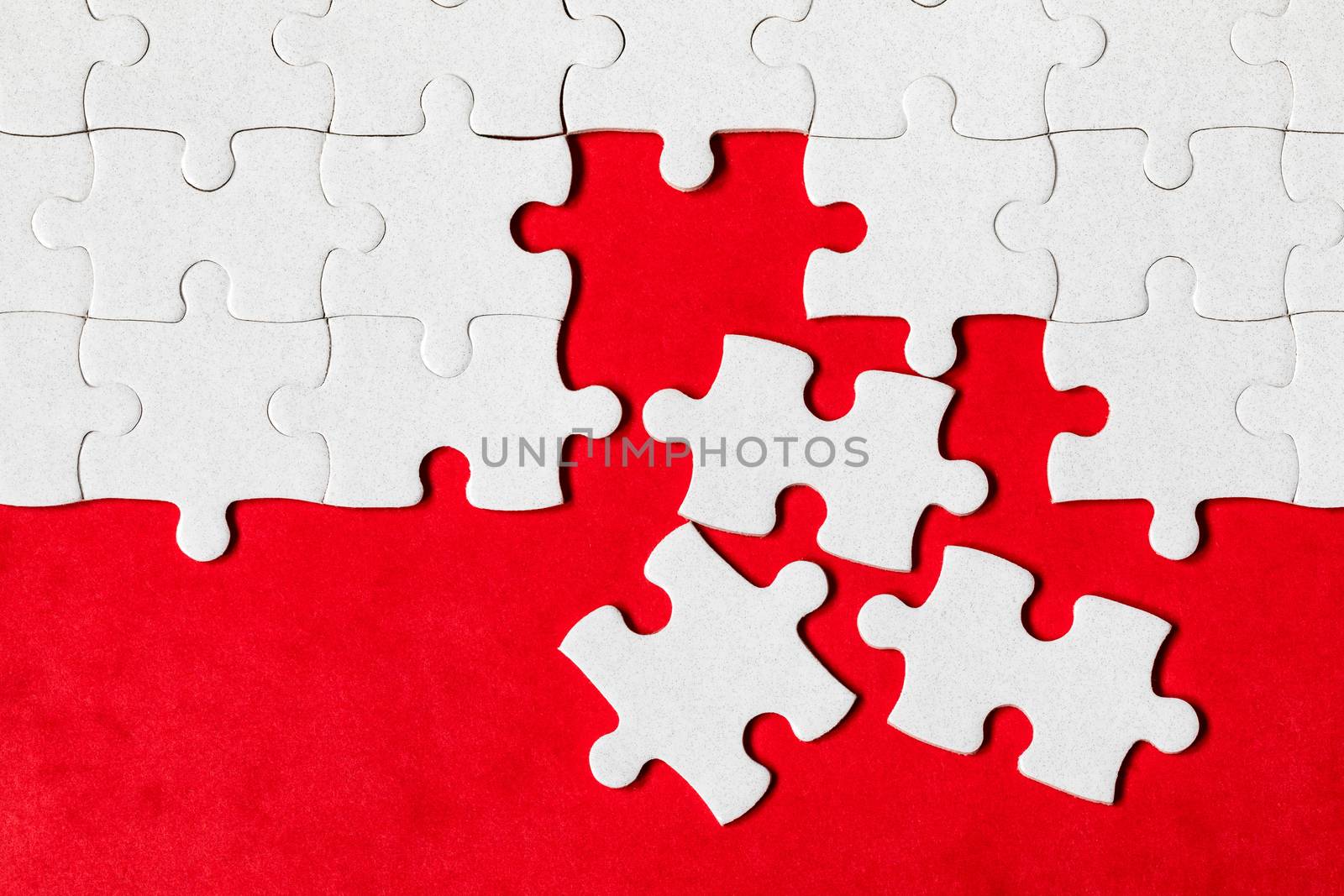 White jigsaw puzzle. White puzzle pieces on color background. Unfinished white jigsaw puzzle pieces on color background. 