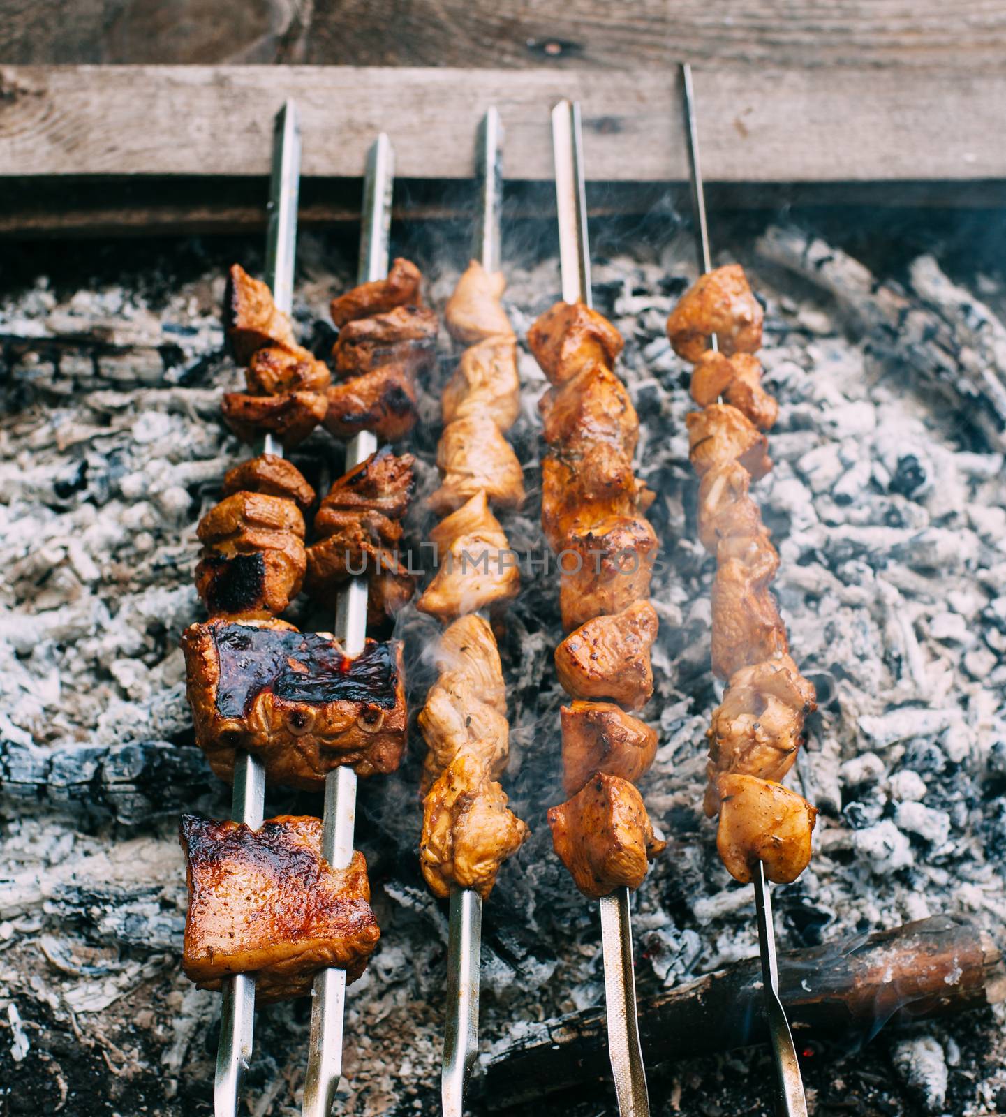 Chicken skewers on skewers on fire. Cooking meat outdoors in the open air.