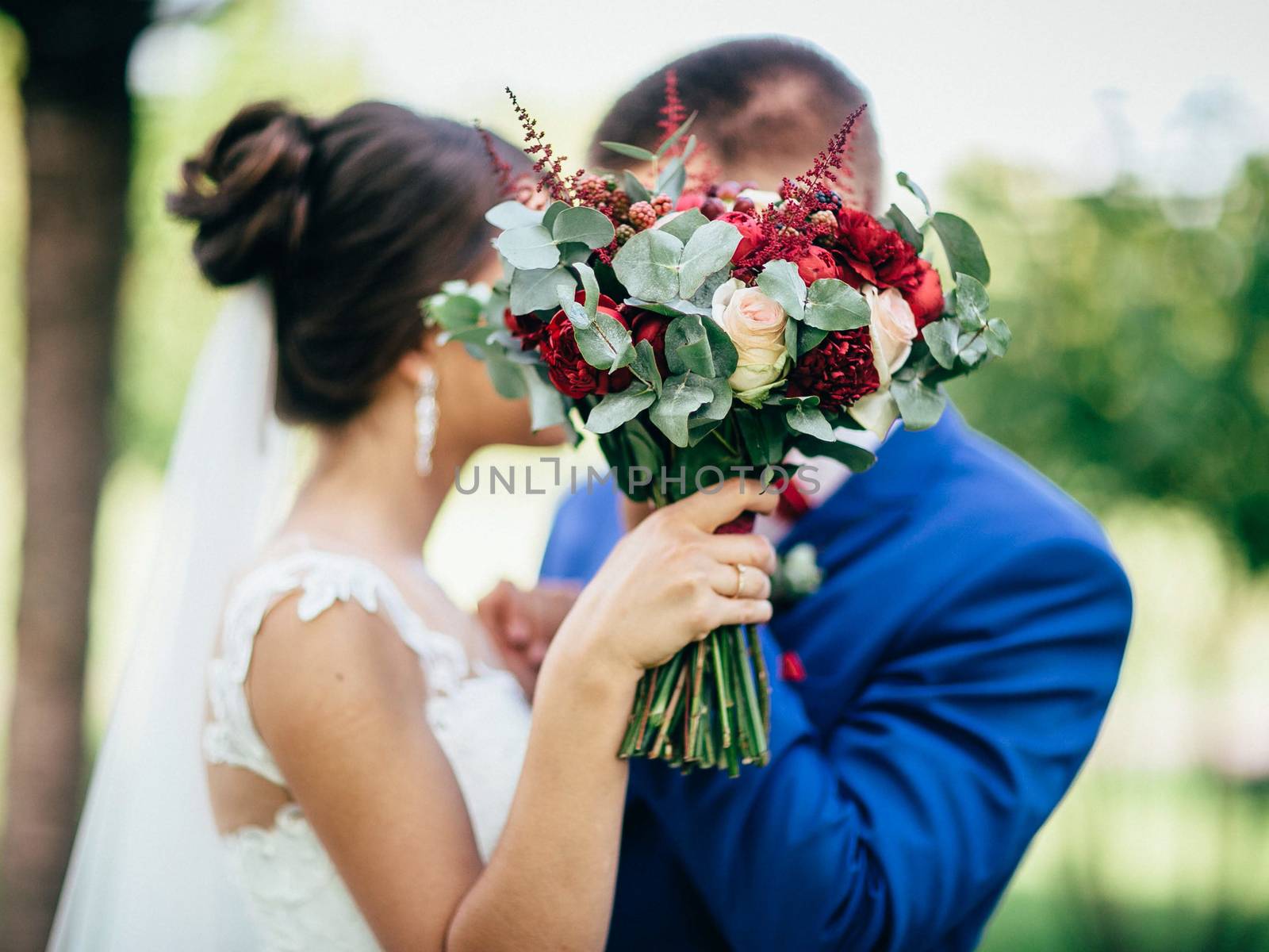 Bridal bouquet on the background of the groom with the bride. Br by Opikanets