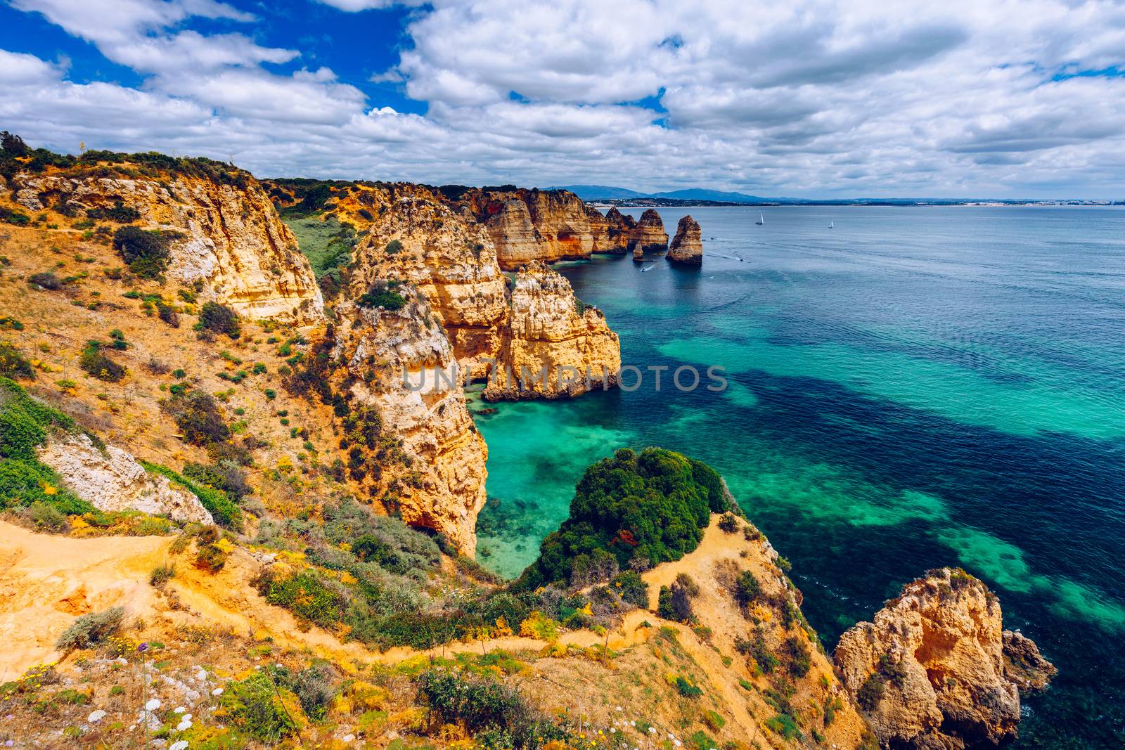 Panoramic view, Ponta da Piedade near Lagos in Algarve, Portugal. Cliff rocks and tourist boat on sea at Ponta da Piedade, Algarve region, Portugal. Ponta da Piedade, Algarve region, Portugal.