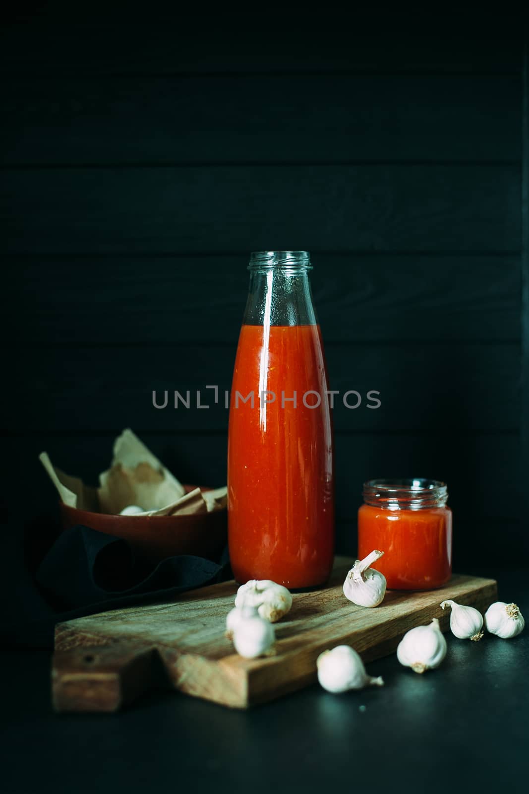 Tomato juice in a jar with a chapel on a wooden board