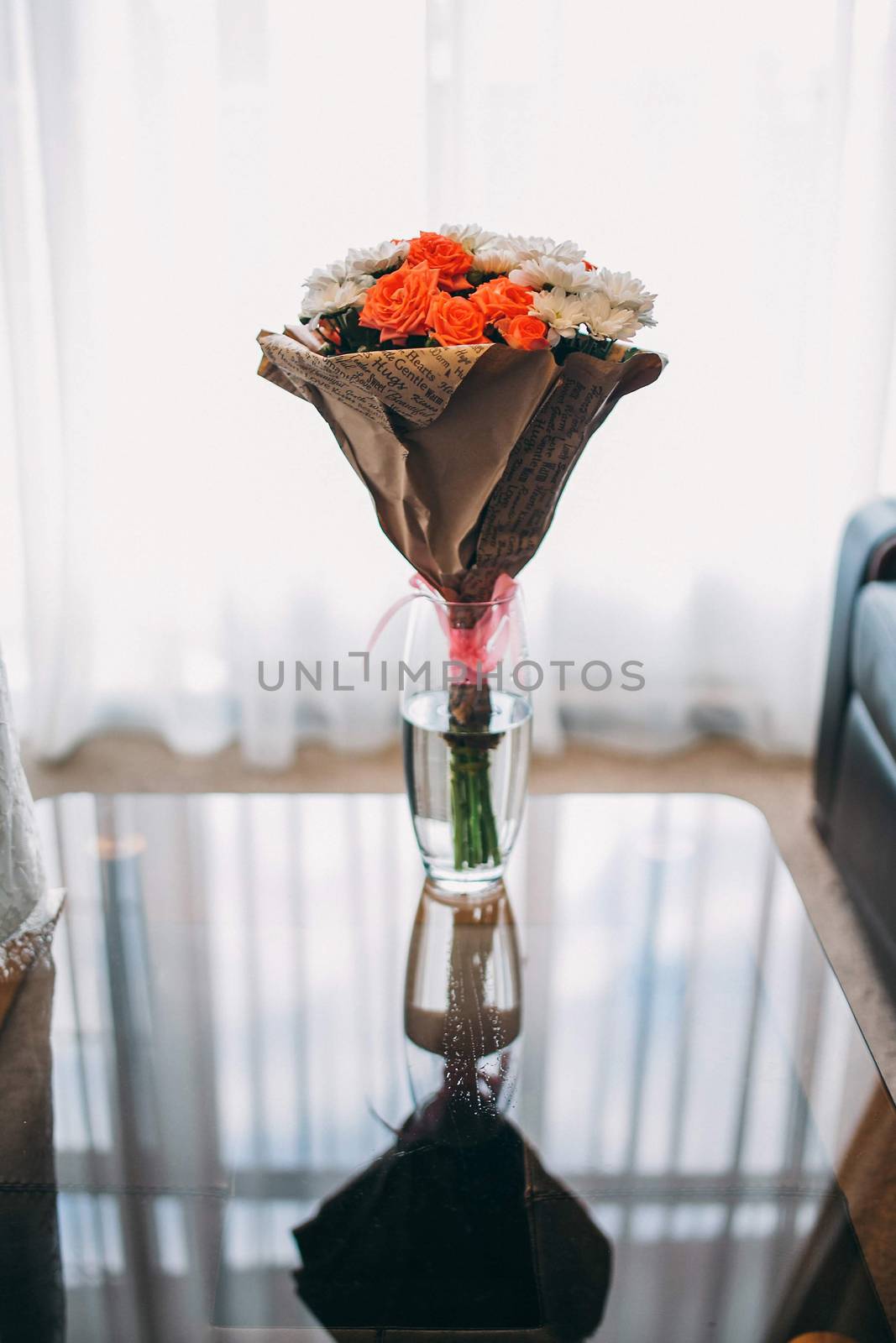Bouquet of pink roses and white asters wrapped in paper. Close-u by Opikanets