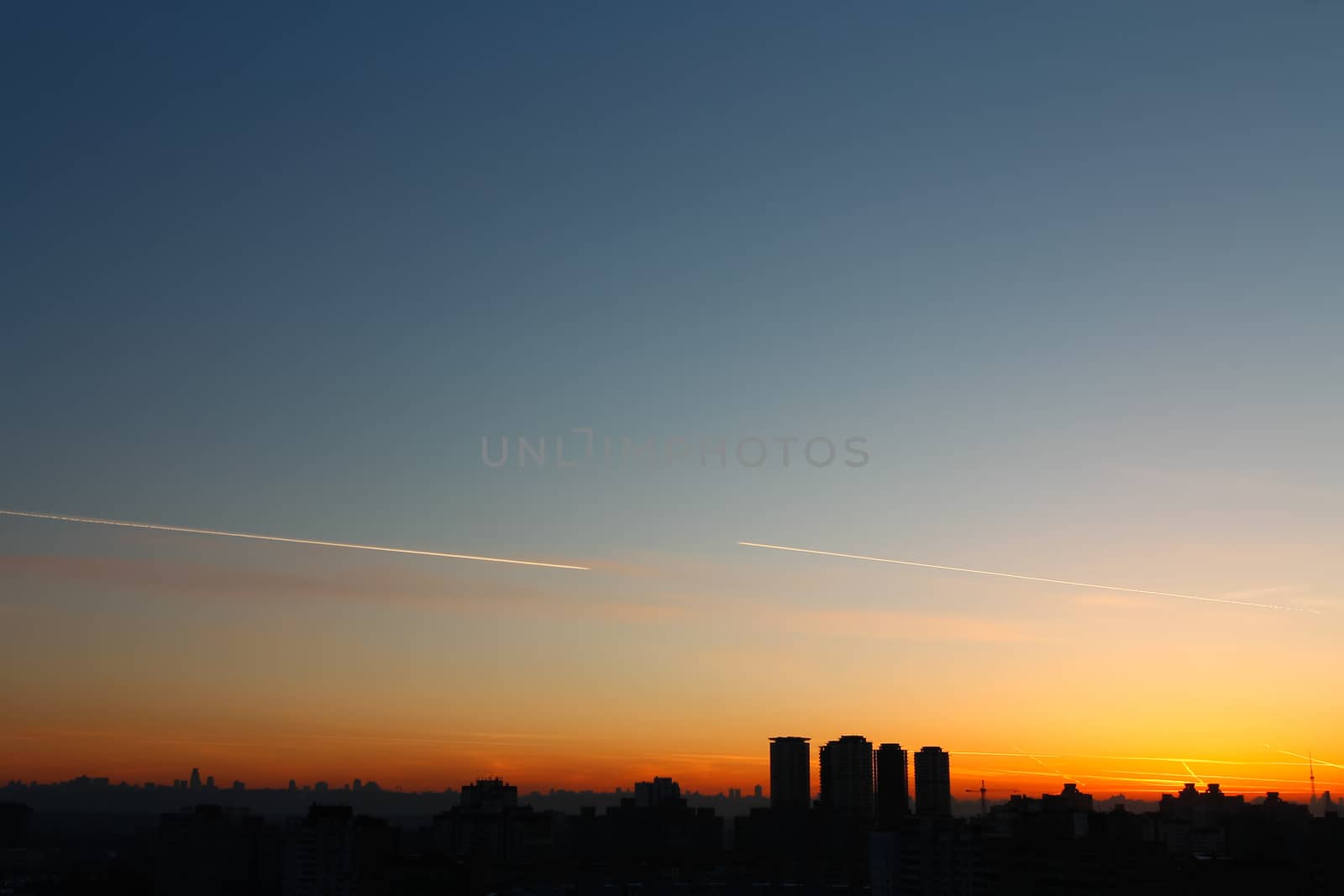 Silhouette of urban buildings on a background of beautiful sunse by Opikanets