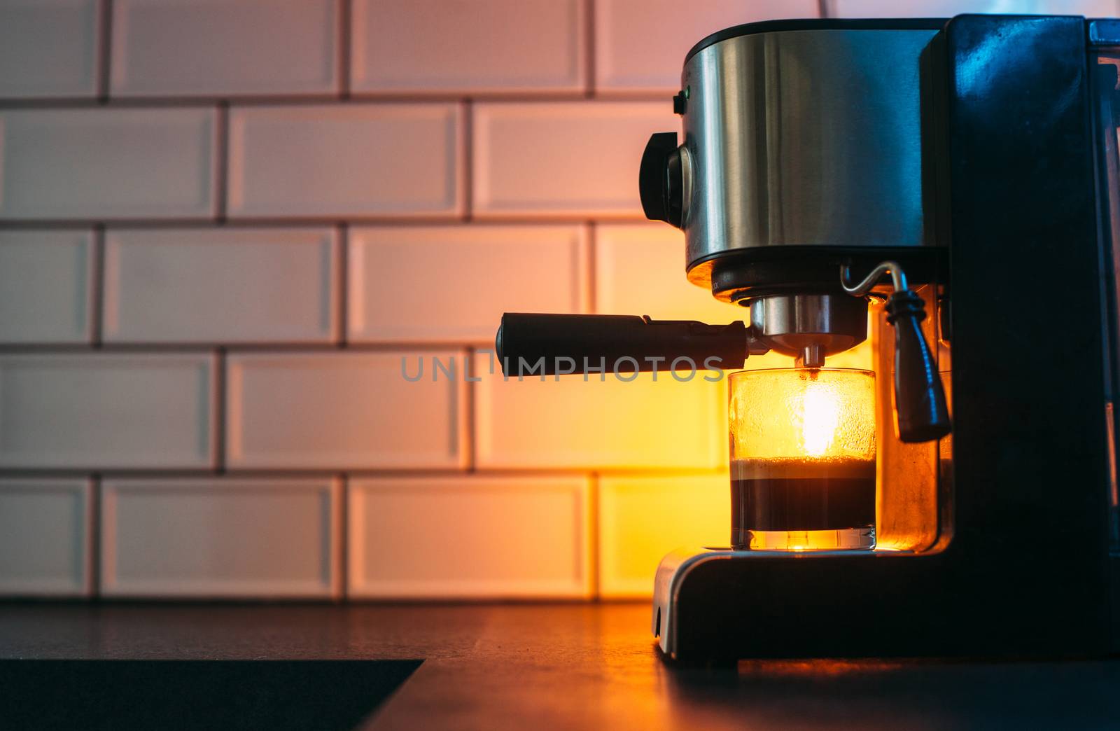 A filling glass is standing in a coffee machine with a yellow li by Opikanets