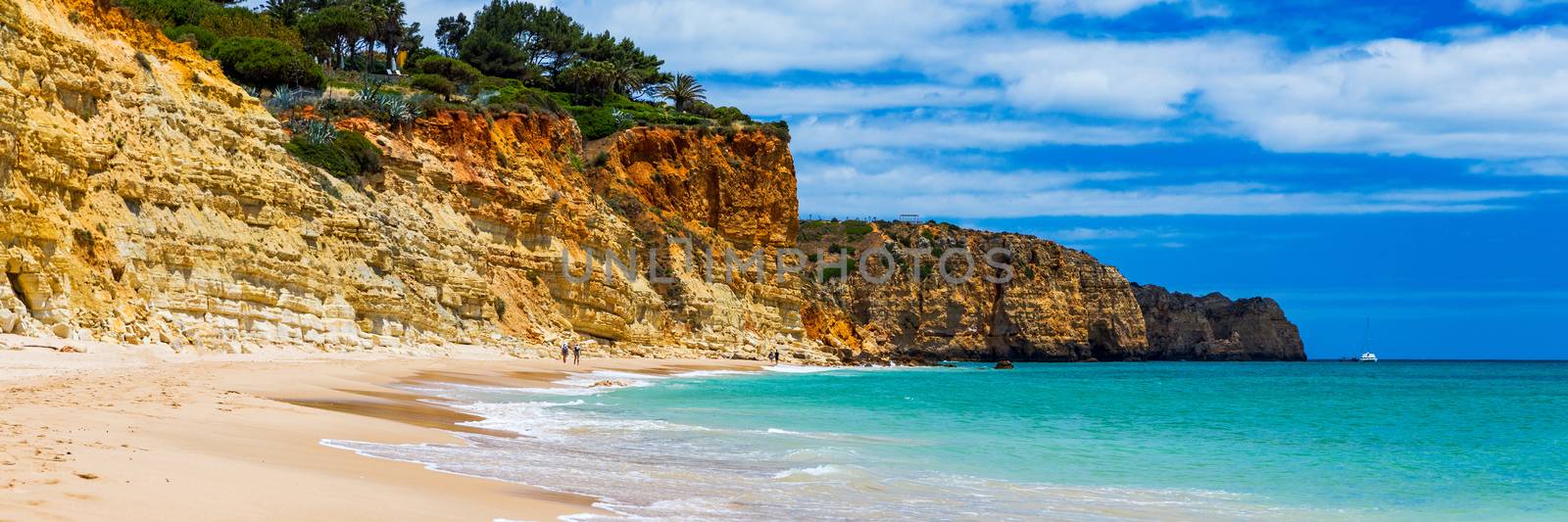 Praia de Porto de Mos in Lagos, Portugal. Praia do Porto de Mos, long beach in Lagos, Algarve region, Portugal. Beautiful golden beach, surrounded by impressive rock formations. 