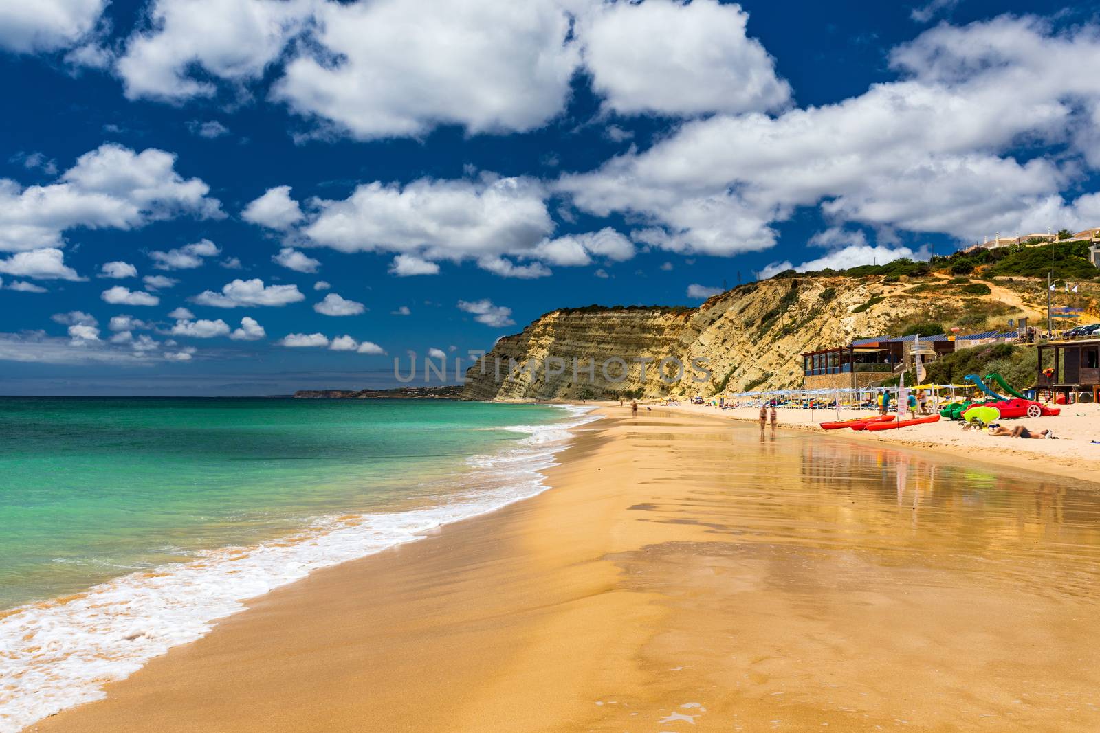 Praia de Porto de Mos in Lagos, Portugal. Praia do Porto de Mos, long beach in Lagos, Algarve region, Portugal. Beautiful golden beach, surrounded by impressive rock formations. 