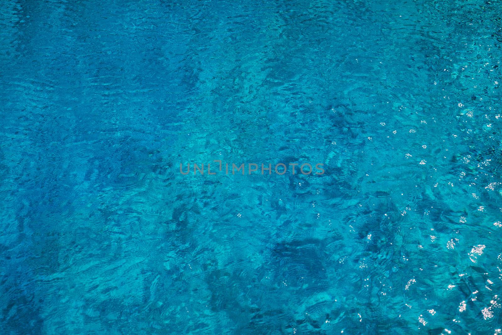 Blue ripped water in swimming pool. Surface of blue swimming pool, background of water in swimming pool. Water swimming pool texture and surface water on pool. Blue ripped water in swimming pool.