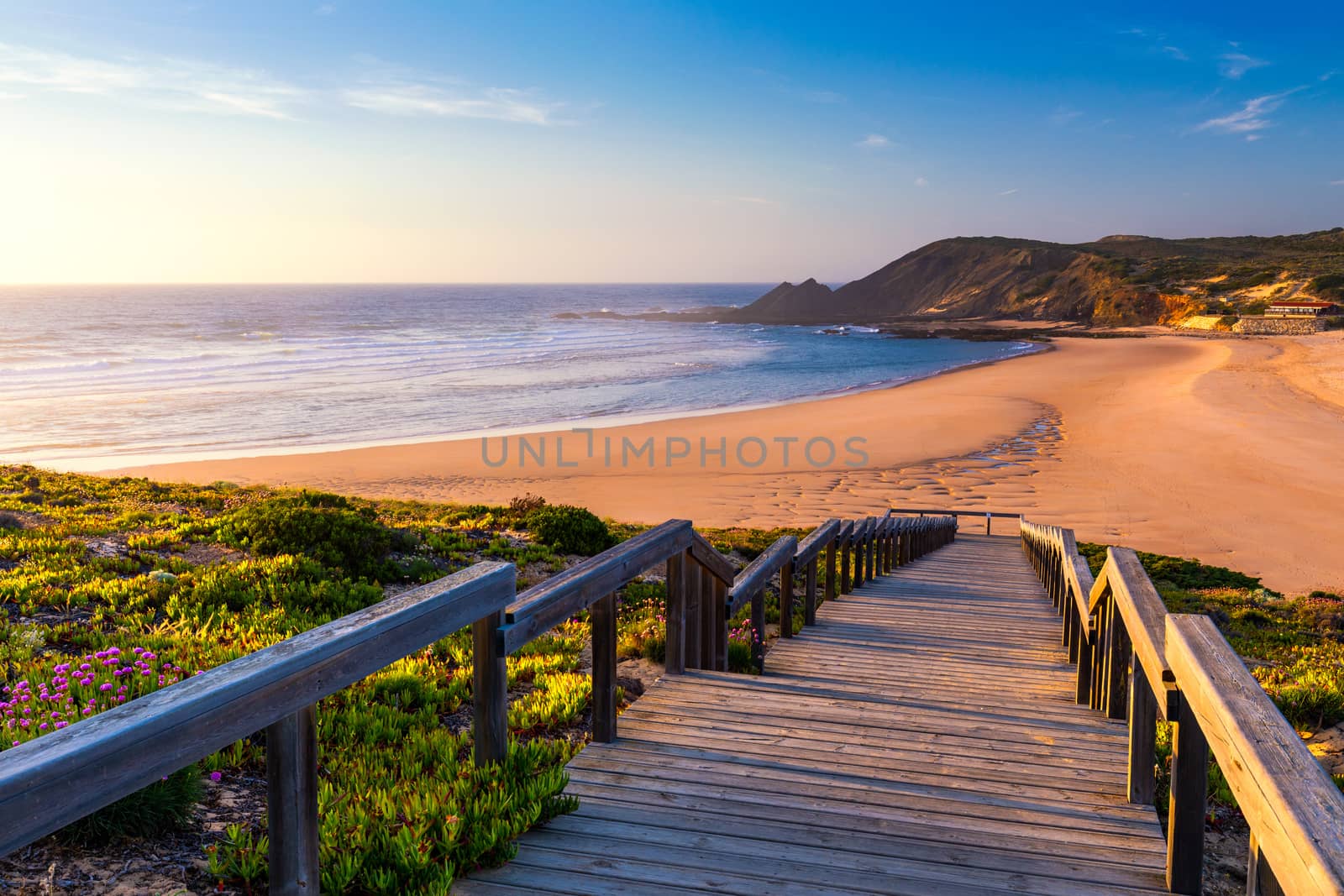 Wooden walkway to the beach Praia da Amoreira, District Aljezur, Algarve Portugal. Panorama from Amoreira beach in the Algarve Portugal. Beach and estuary of the Aljezur river, Praia da Amoreira.