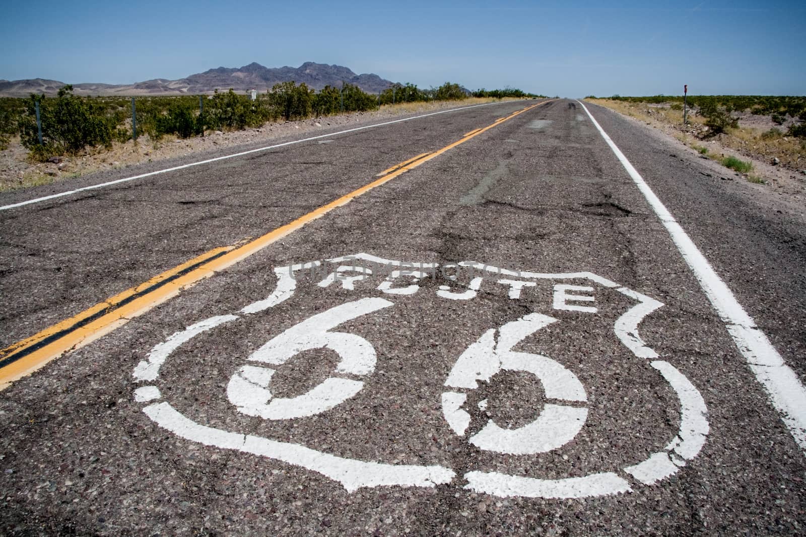 long road with a Route 66 sign painted on it by tanaonte