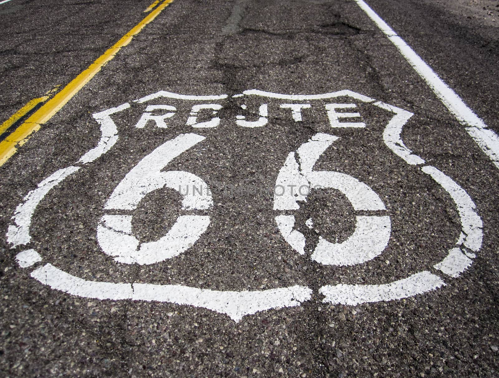 Long US road with a Route 66 sign painted on it