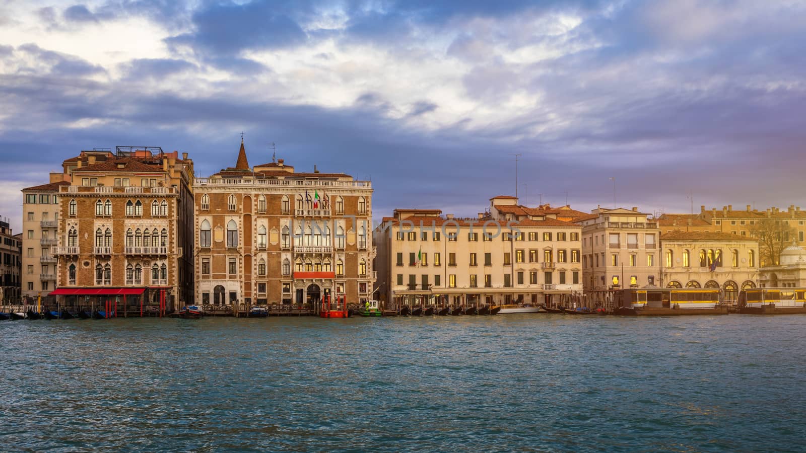View of the street canal in Venice, Italy. Colorful facades of old Venice houses. Venice is a popular tourist destination of Europe. Venice, Italy.