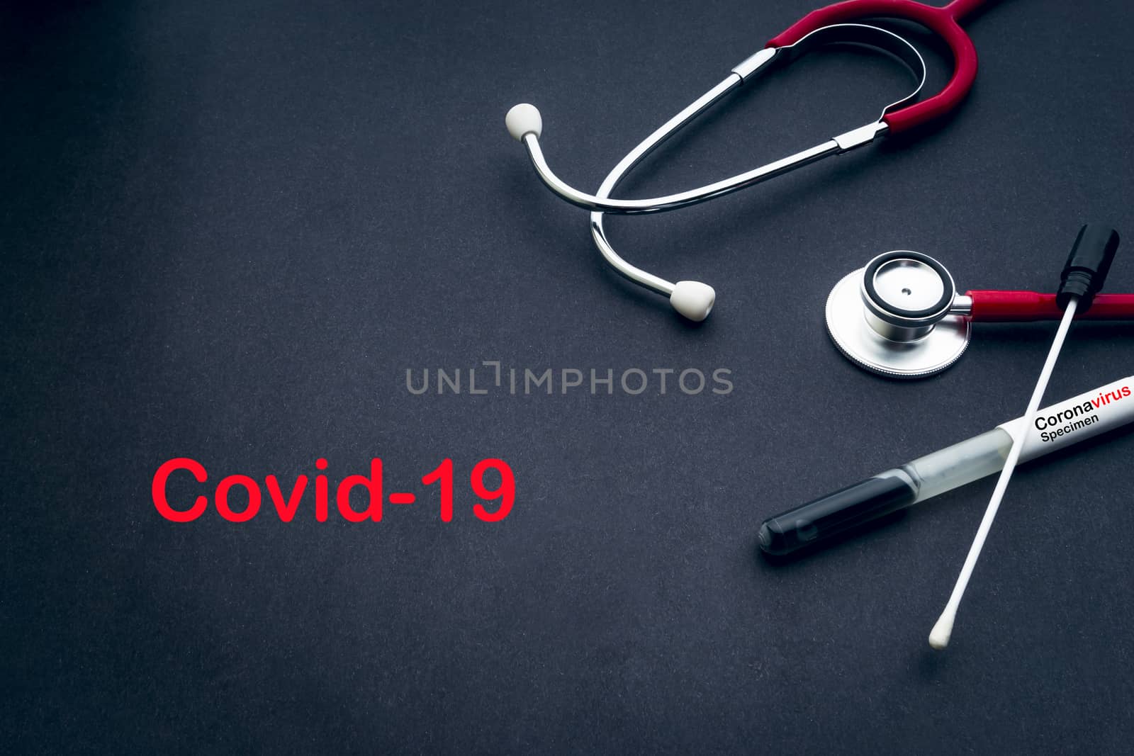 COVID-19 text with stethoscope and medical swabs on black background by silverwings