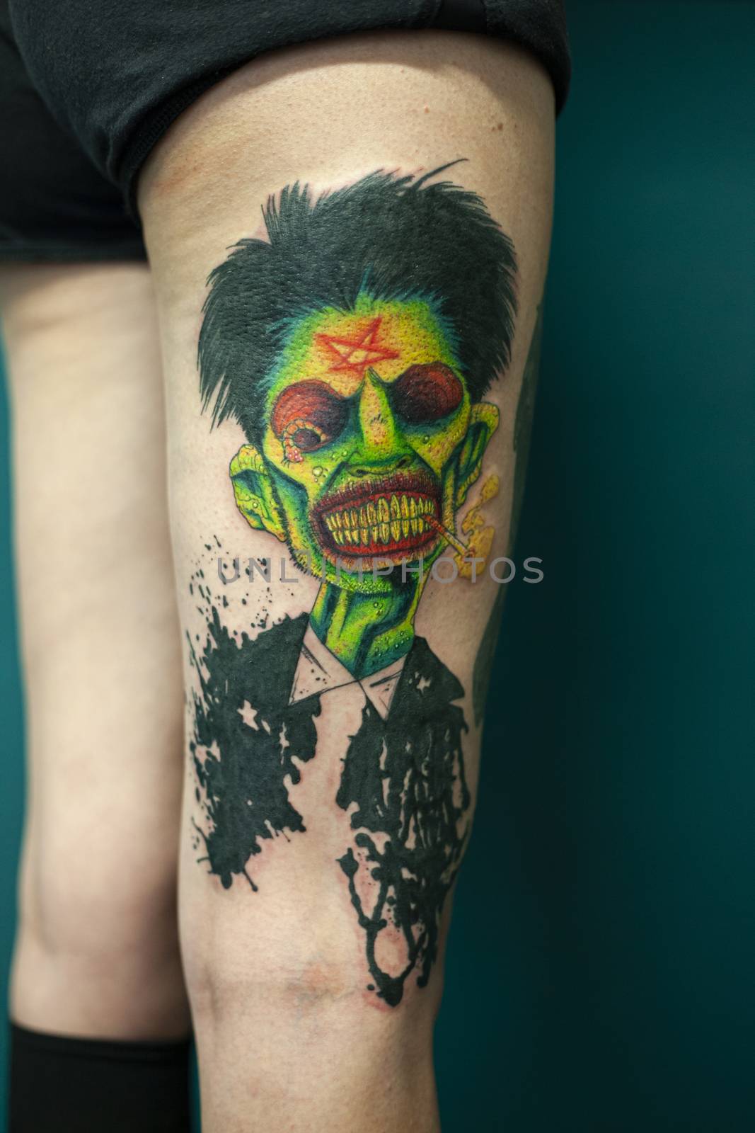 Coloured Tattoo with green face painted in a leg