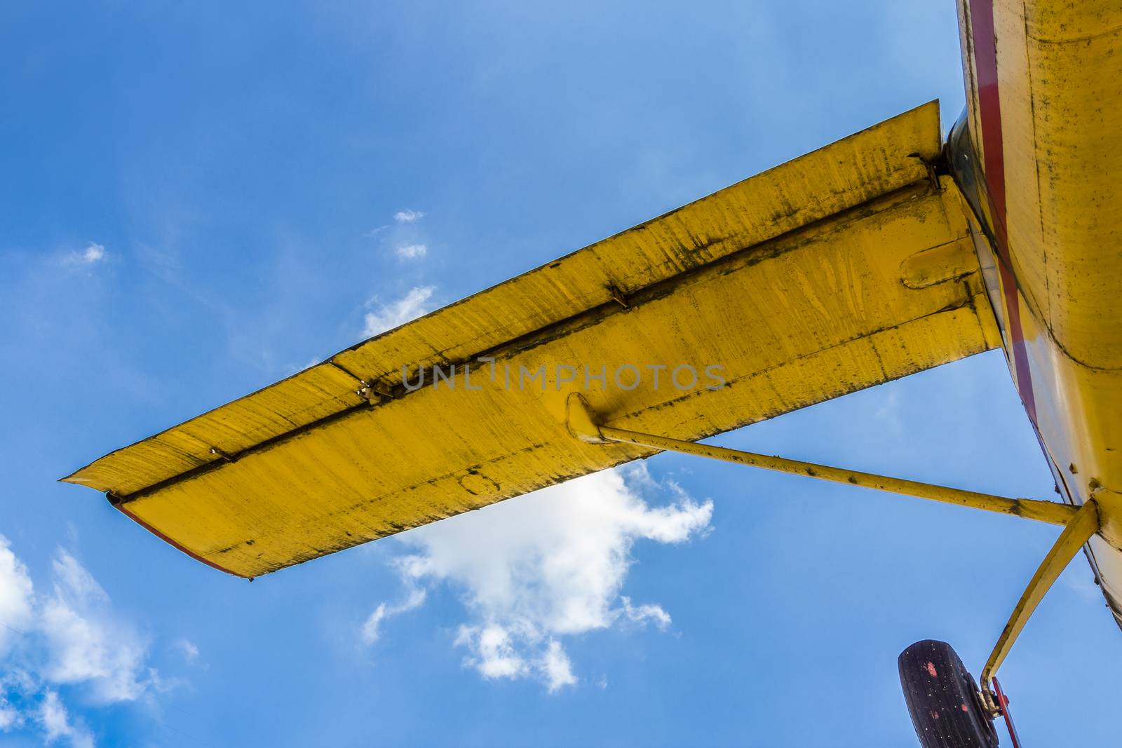 Vintage airplane seen from below, with blue sky in the background