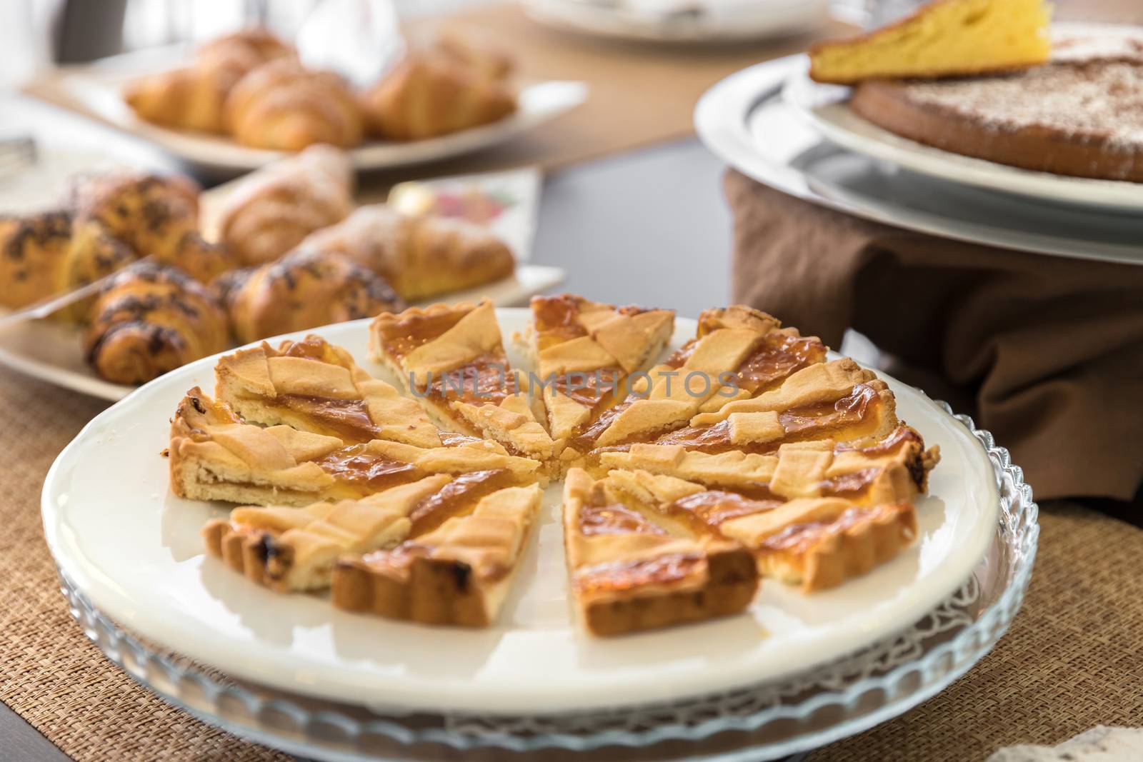 Selection self service continental breakfast buffet display, catering or brunch table food buffet filled with homemade cakes and delicious croissants in a hotel or restaurant setting.