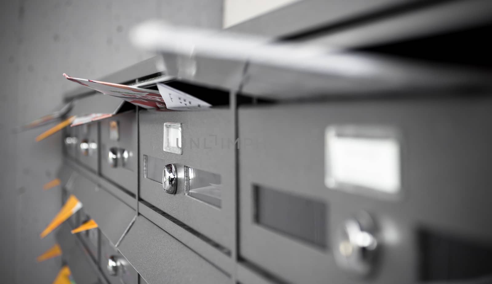 Mail boxes filled of leaflets and letters. Shallow DOF.
