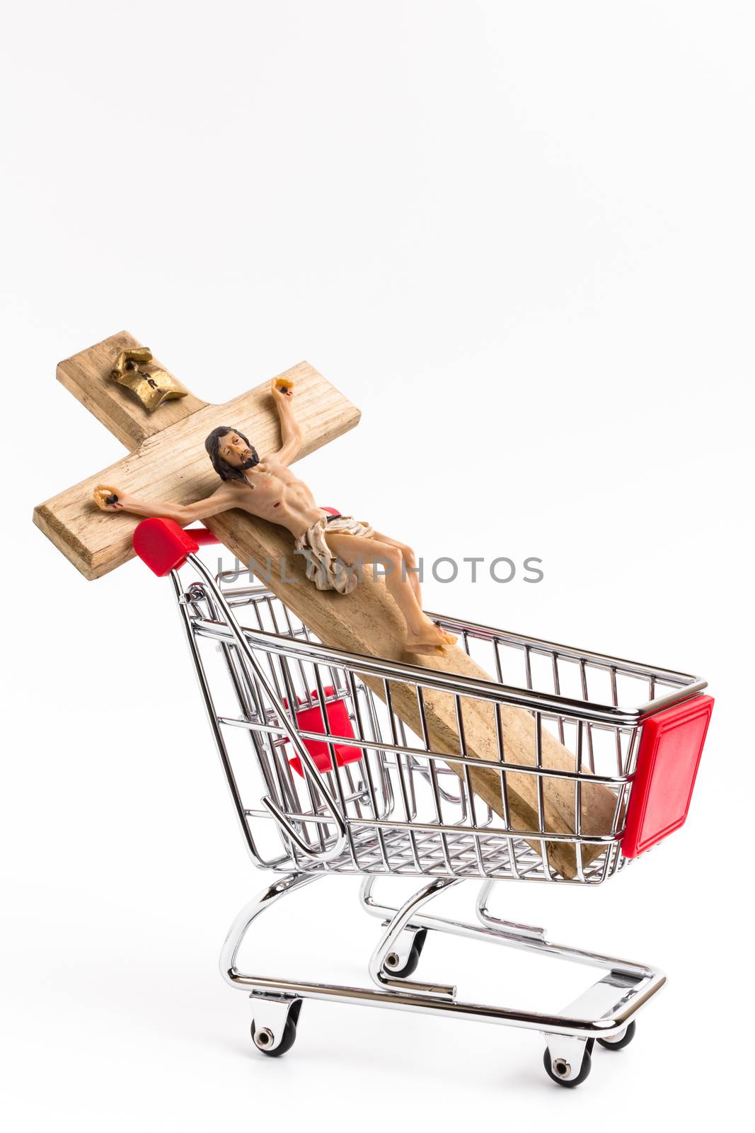 Crucifix in shopping cart. Conceptual representation of commodification of religion, loss of faith, blasphemy.