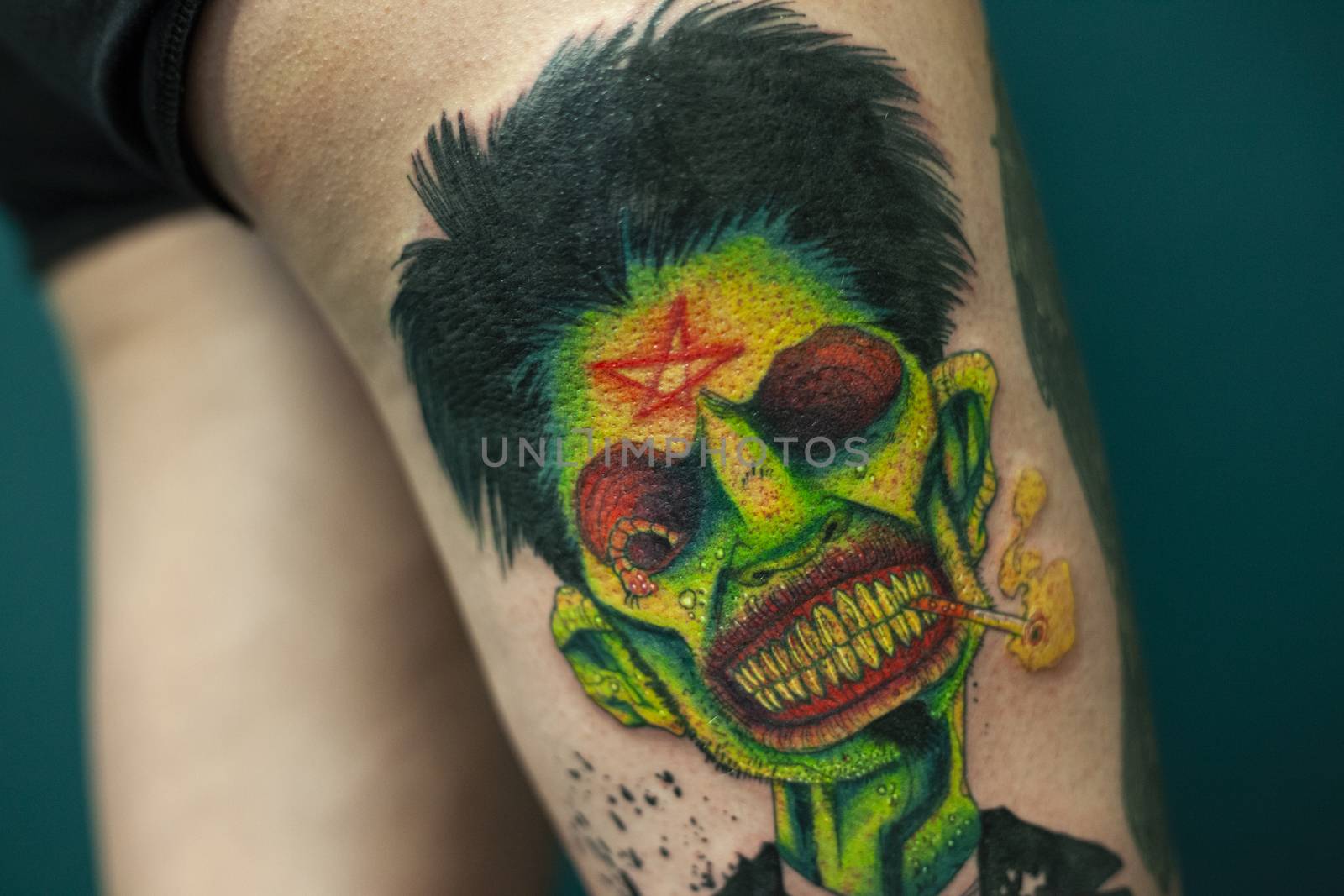 Coloured Tattoo with green face painted in a leg