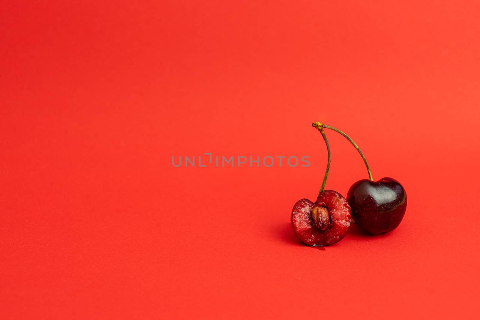 Two cherries on a deep red background by Dumblinfilms