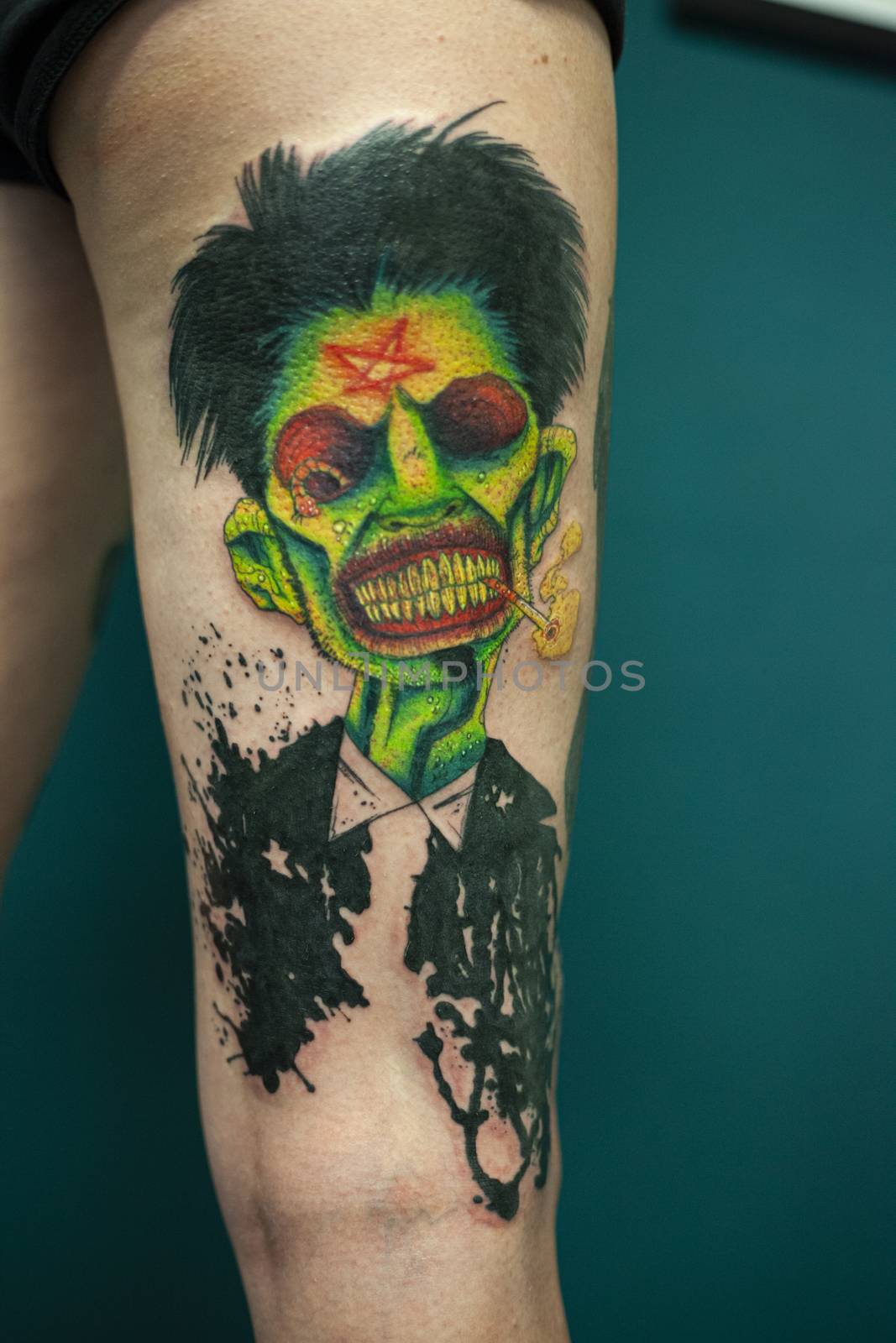 Coloured Tattoo with green face painted in a leg