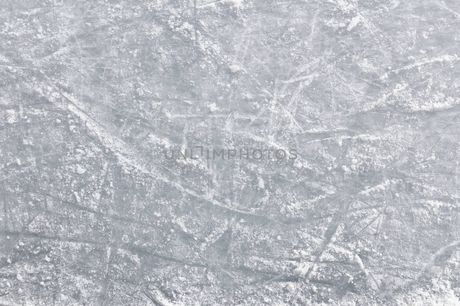 Details of an ice skating rink, with marks and scratches of skate blades.