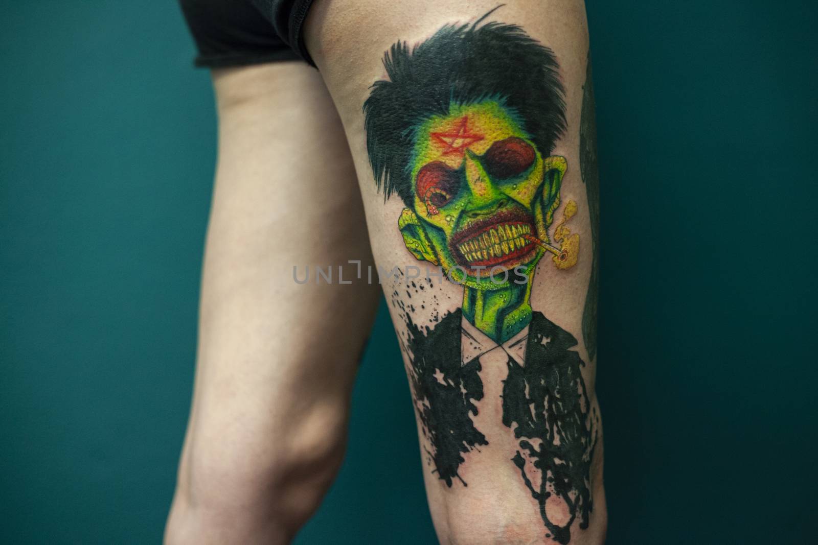 Coloured Tattoo with green face painted in a leg