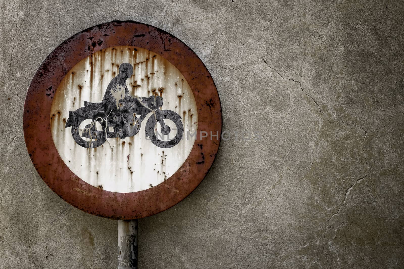 Road sign ban for motorcycles, rusted from the elements.